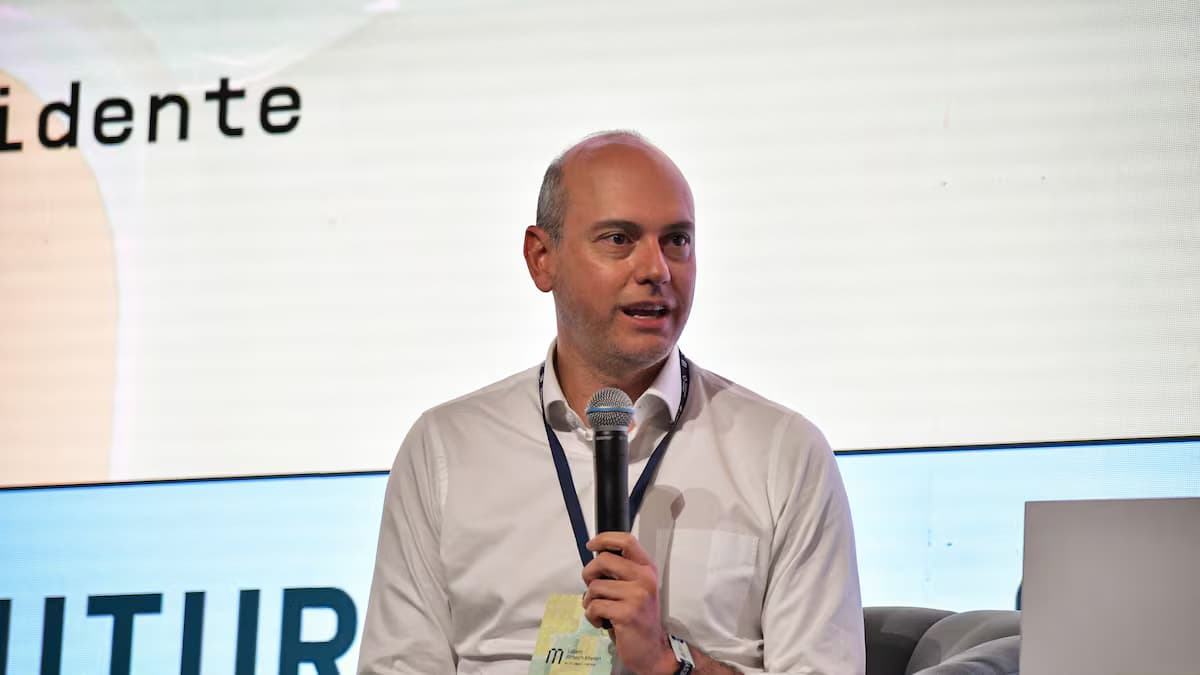 José Ignacio López, presidente de Anif, habla con un micrófono en la mano sentado en un sillón durante un foro