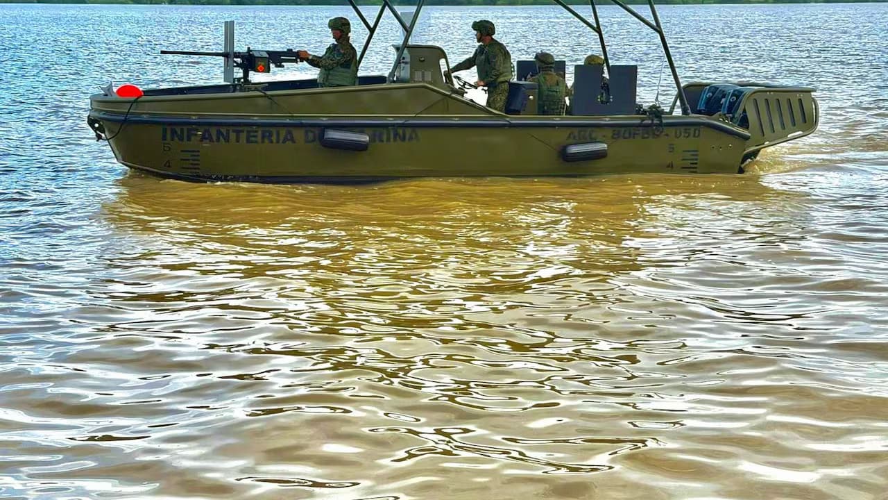 Lancha de la Infantería de Marina con uniformados armados navega por un río del Pacífico colombiano
