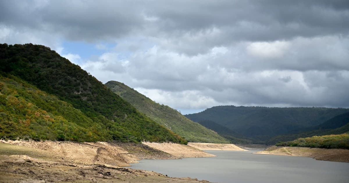 Embalse con el nivel del agua bajo y las orillas descubiertas entre montañas
