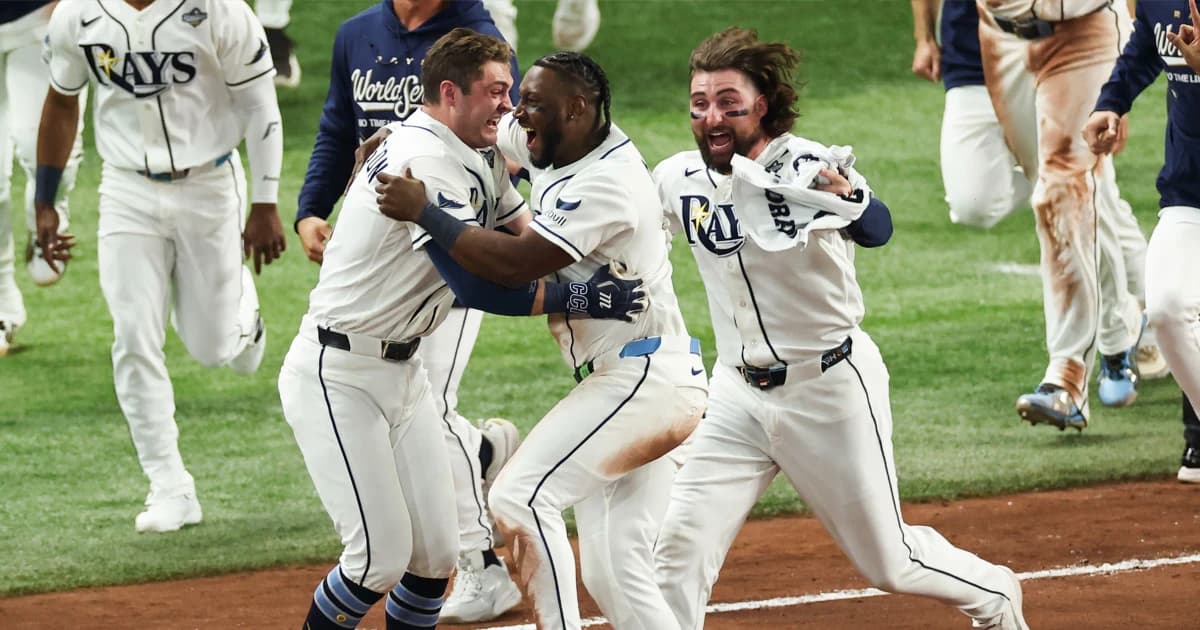 Ben Williamson celebra con sus compañeros de los Rays tras el sencillo que dio la victoria ante los Cerveceros