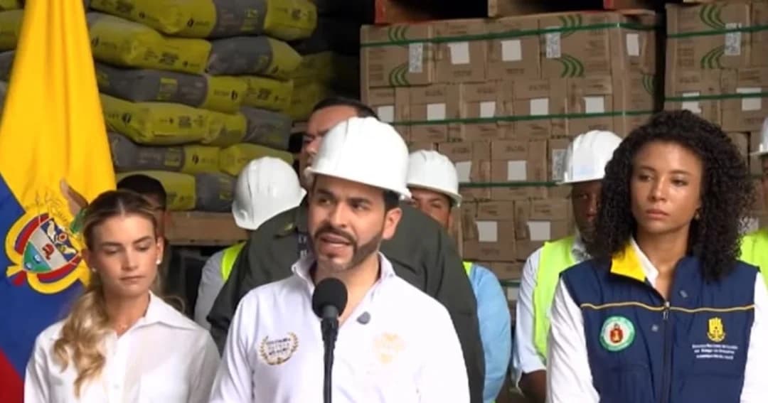 El presidente Abelardo de la Espriella, con casco blanco, habla ante un micrófono en una bodega de ayudas humanitarias