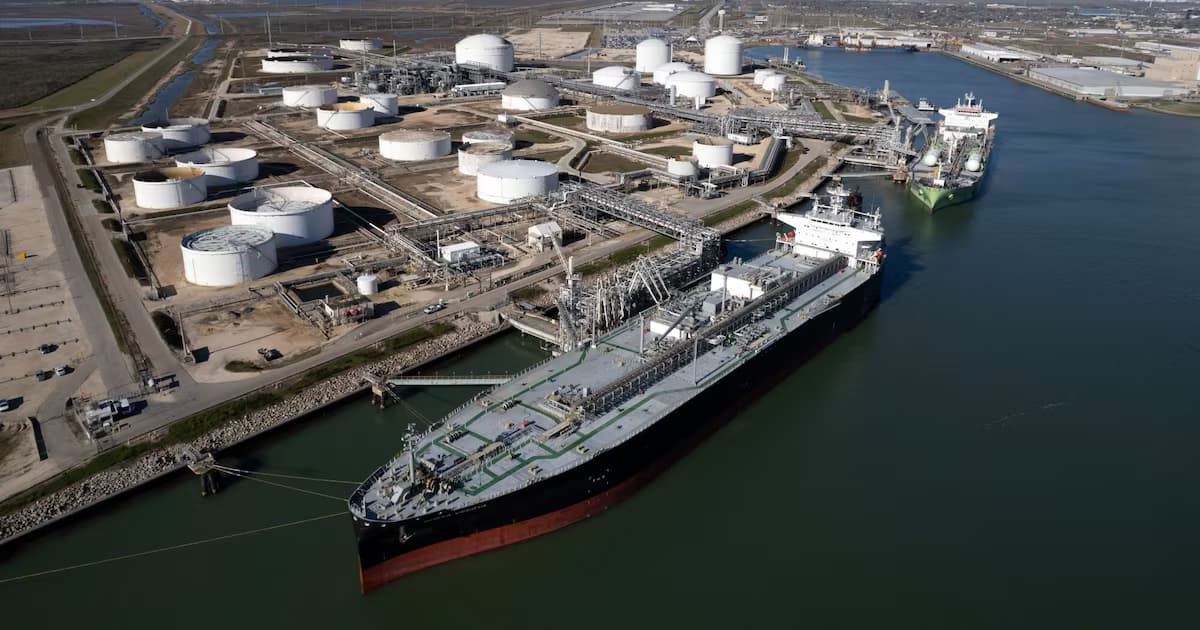 Vista aérea de un buque petrolero atracado junto a tanques de almacenamiento en una terminal portuaria