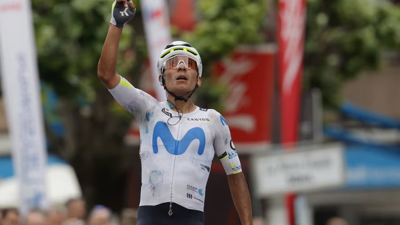 Nairo Quintana levanta el brazo al cruzar la meta con el uniforme del Movistar