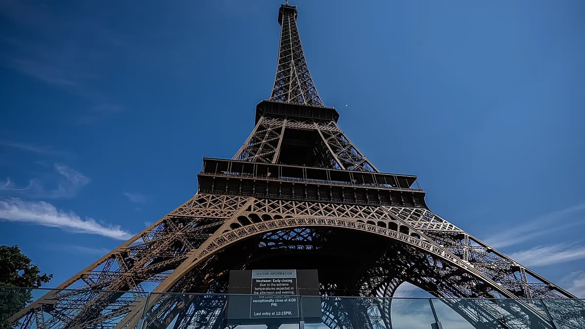 La base de la Torre Eiffel vista desde abajo, con un aviso para visitantes
