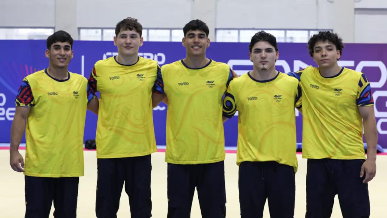 Cinco integrantes de la selección masculina de gimnasia artística de Colombia posan con la camiseta amarilla