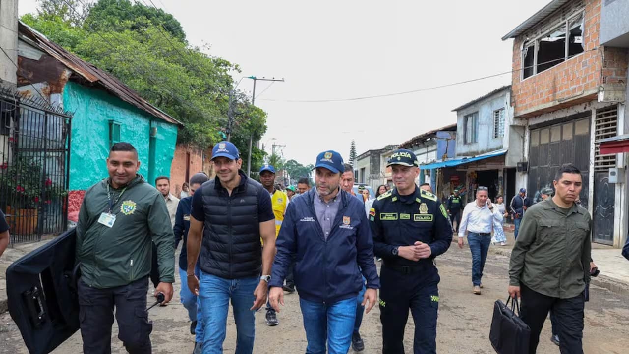 El alcalde Alejandro Eder recorre una calle de Cali acompañado por funcionarios y un oficial de la Policía
