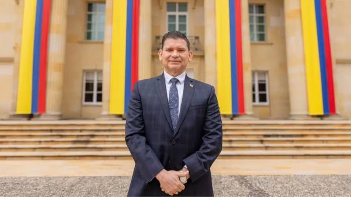John Milton Rodríguez, de pie frente a la fachada de la Casa de Nariño engalanada con banderas de Colombia