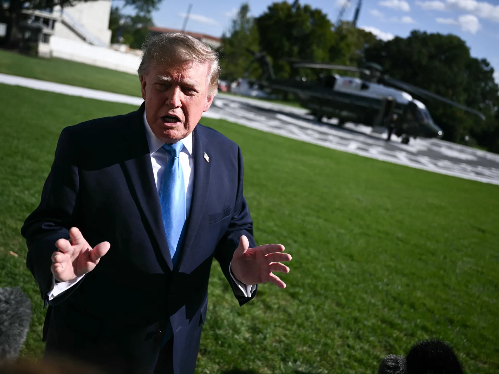 Donald Trump habla con periodistas en los jardines de la Casa Blanca, con el helicóptero presidencial al fondo