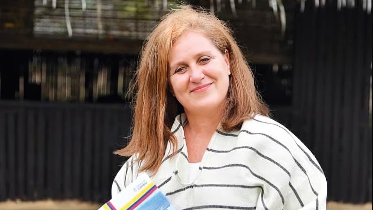 Eva Ferrer, exconsejera presidencial, sonríe al aire libre con una publicación en la mano