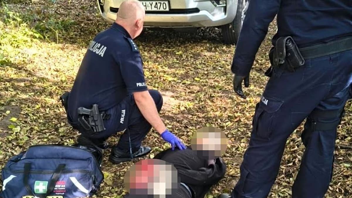 Policías polacos junto al joven detenido en la playa municipal a orillas del río Narew, en Ostrołęka