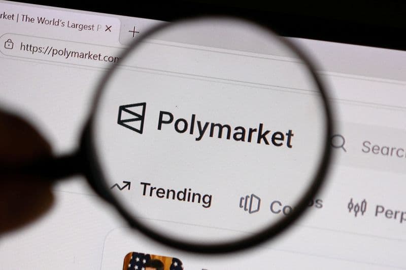 El logotipo de Polymarket visto a través de una lupa en la pantalla de un computador