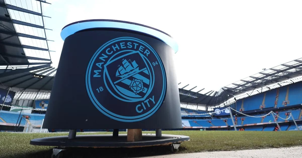 Escudo del Manchester City junto al césped del estadio Etihad