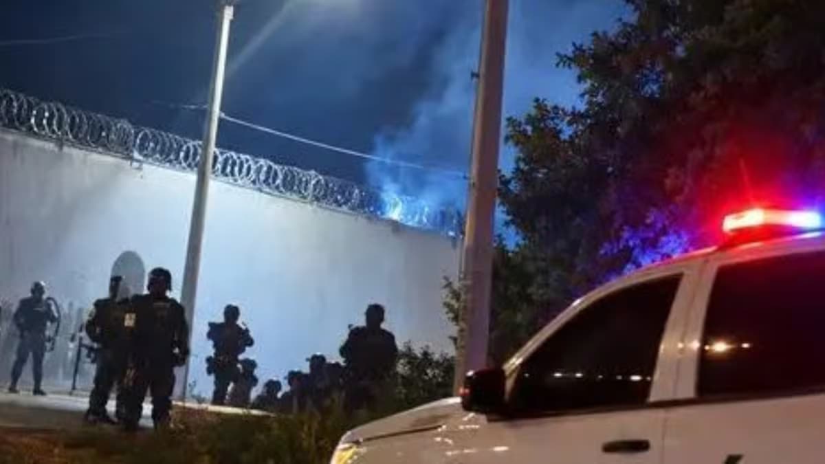 Policías frente al muro de un centro de detención en Santa Marta, de noche