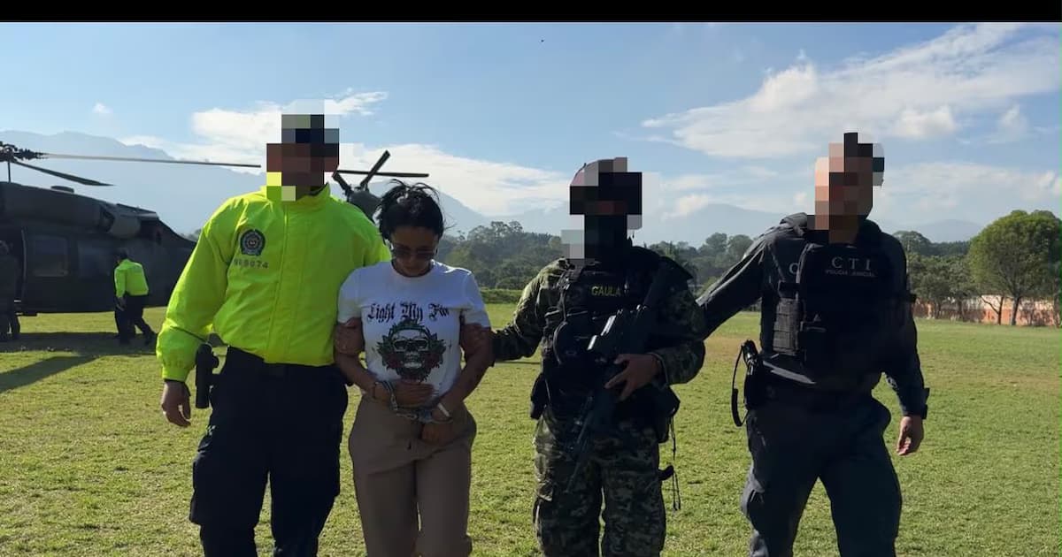 Uniformados de la Policía, el Gaula y el CTI conducen a una mujer capturada junto a un helicóptero militar