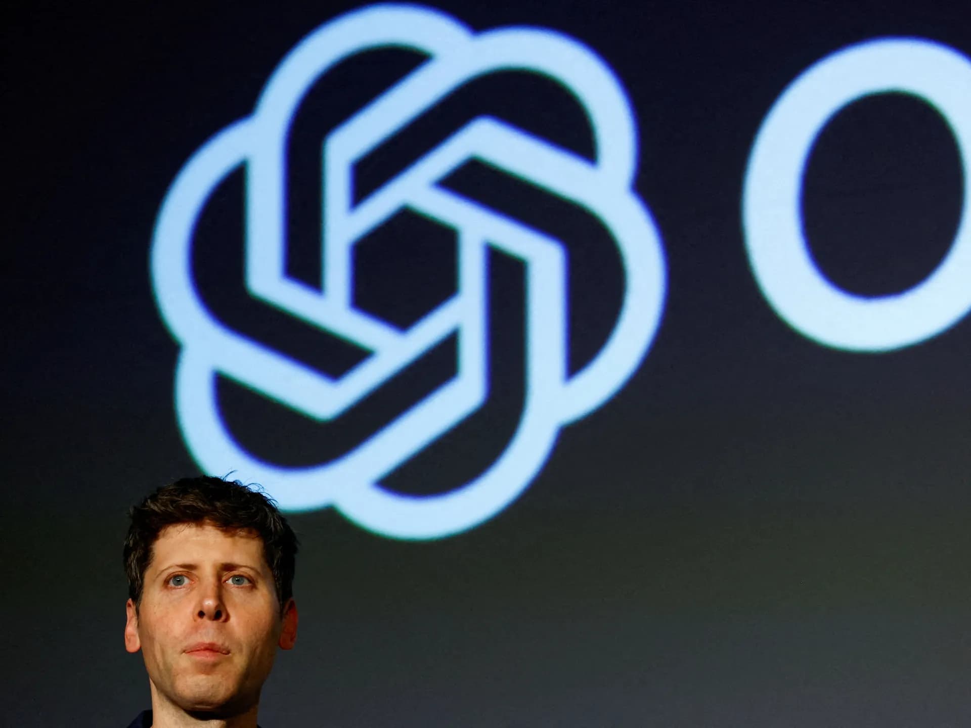 Sam Altman, director ejecutivo de OpenAI, frente al logotipo de la empresa en un evento en Tokio