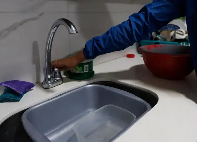 Una persona cierra la llave del lavaplatos durante la campaña de ahorro de agua en Medellín