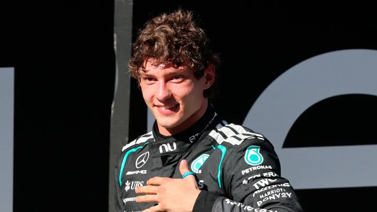 Kimi Antonelli, con el mono negro de Mercedes, sonríe con la mano sobre el pecho