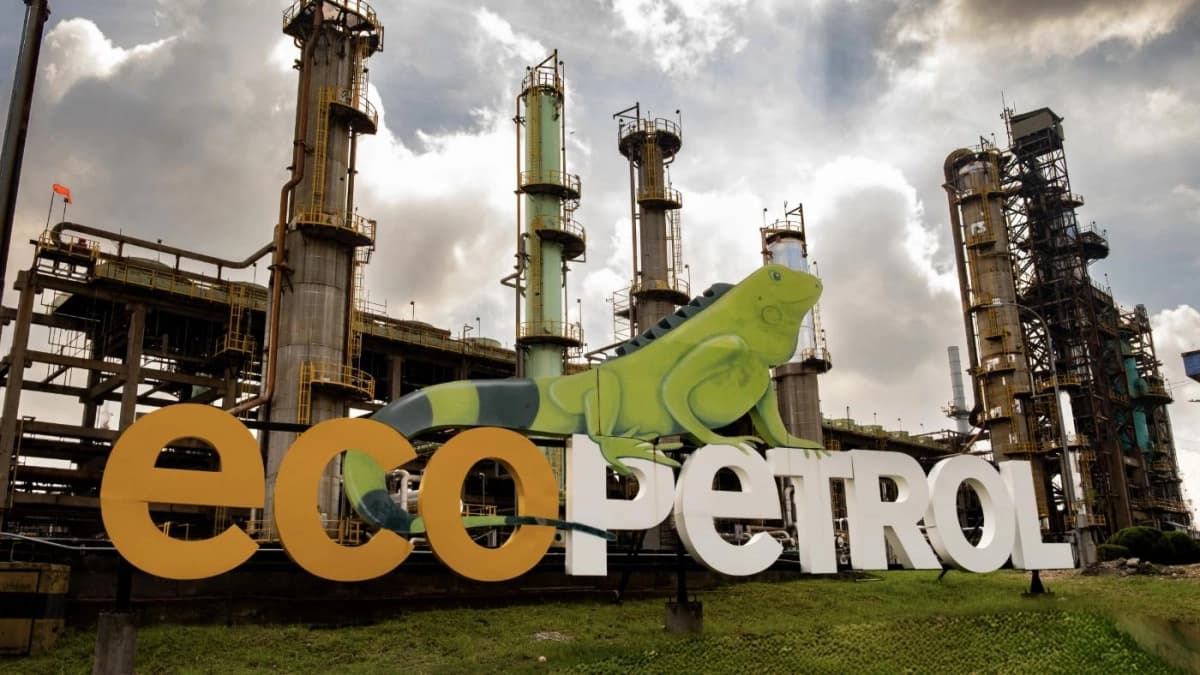 Letras corpóreas con el nombre de Ecopetrol y una iguana pintada, frente a las torres de una refinería