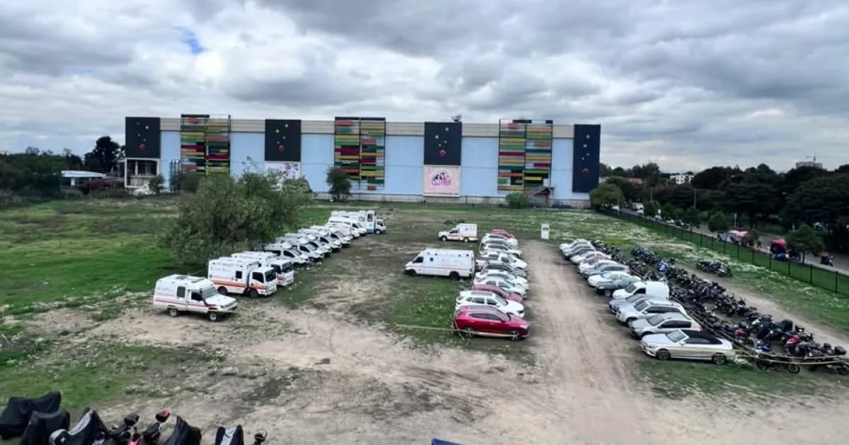 Lote destinado al Hospital de Engativá, con ambulancias y vehículos estacionados frente a un edificio