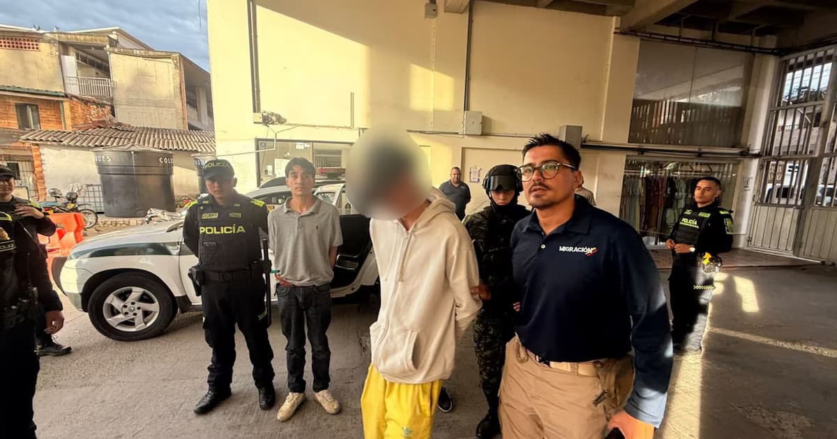 Un extranjero con el rostro difuminado, custodiado por policías, un soldado y un funcionario de Migración Colombia