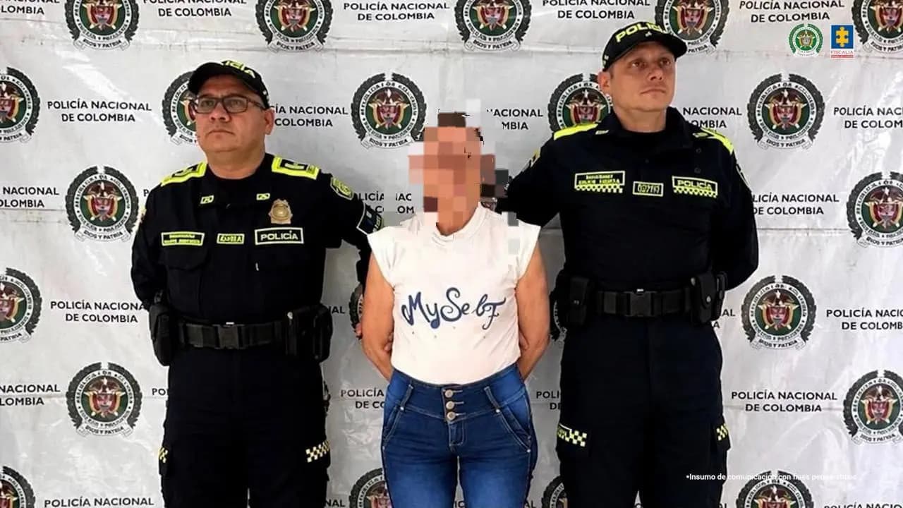 Dos policías custodian a la mujer judicializada por trata de personas, con el rostro difuminado