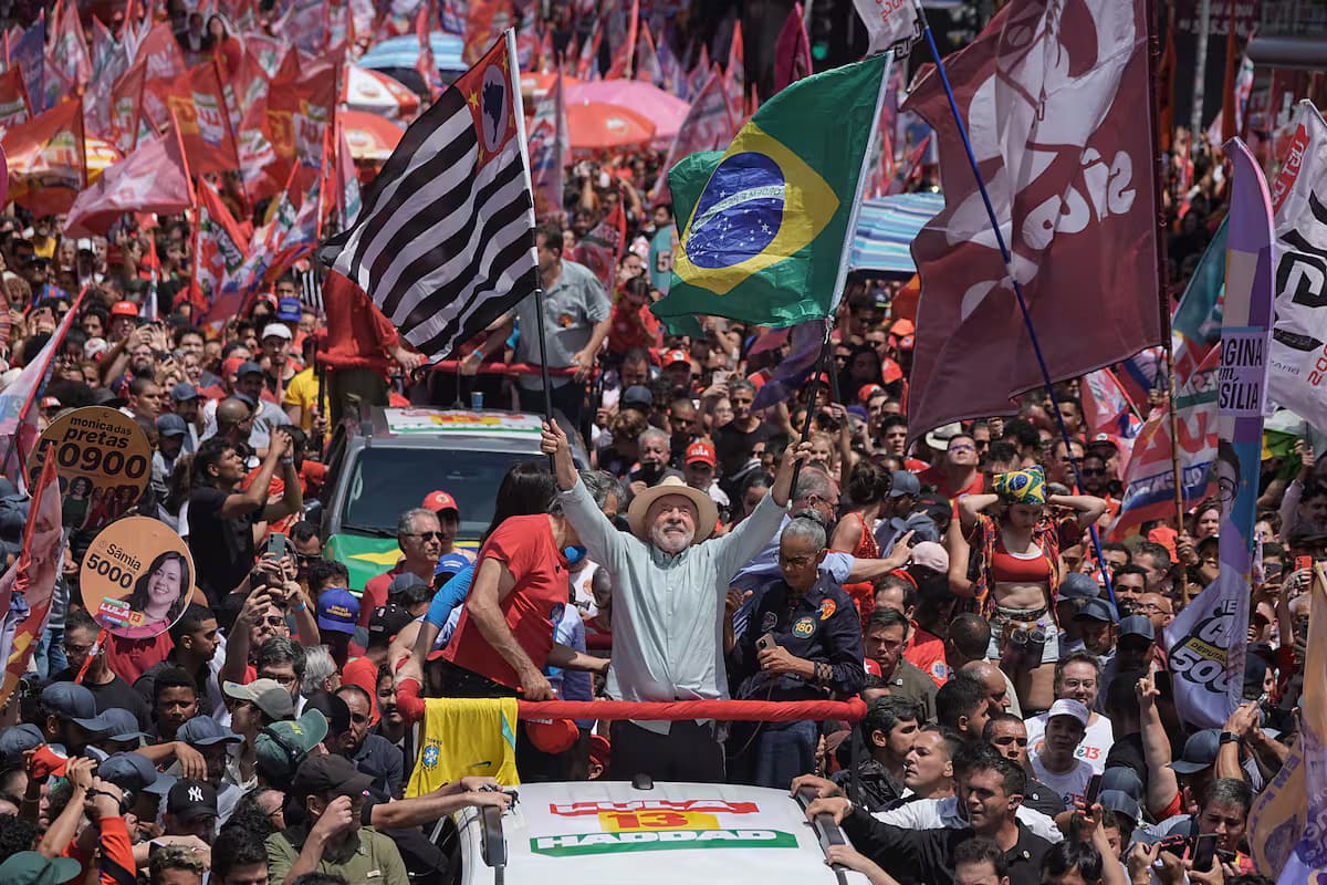 Lula da Silva saluda desde un vehículo de campaña rodeado de una multitud con banderas en São Paulo