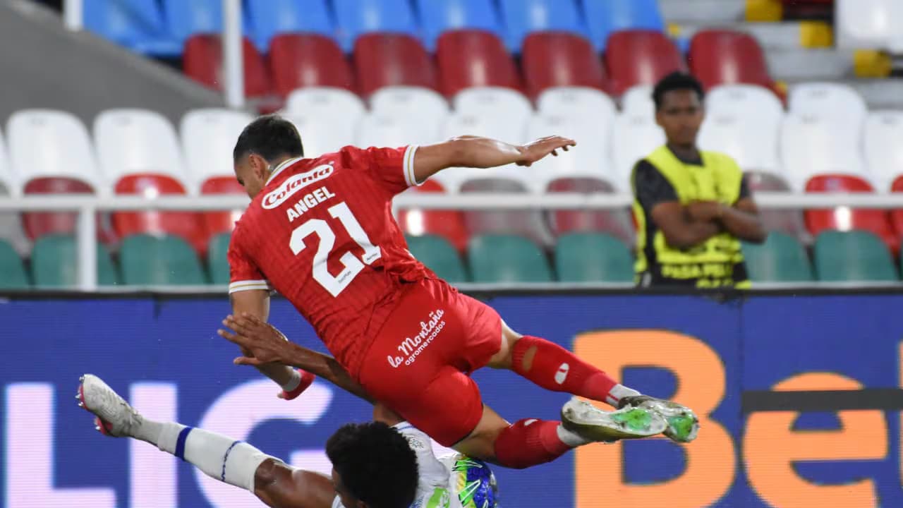 Un jugador del América de Cali salta sobre un rival del Deportivo Pasto en el Pascual Guerrero