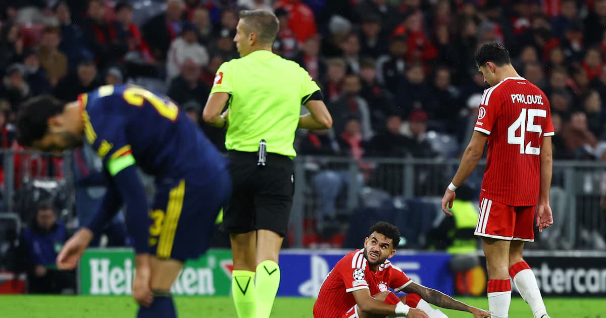 Luis Díaz, sentado en el césped del Allianz Arena con gesto de dolor, durante el partido entre Bayern Múnich y Arsenal