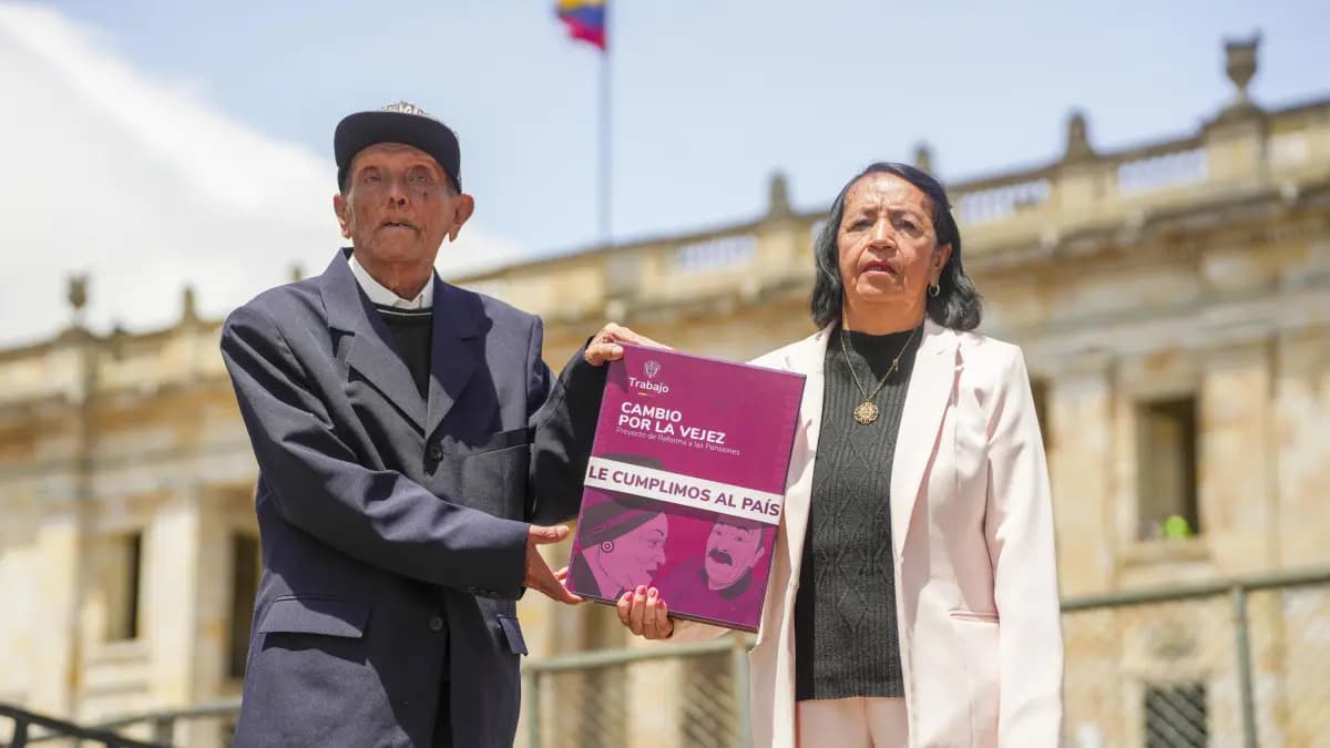 Dos personas mayores sostienen frente al Capitolio Nacional una carpeta con el proyecto de reforma a las pensiones