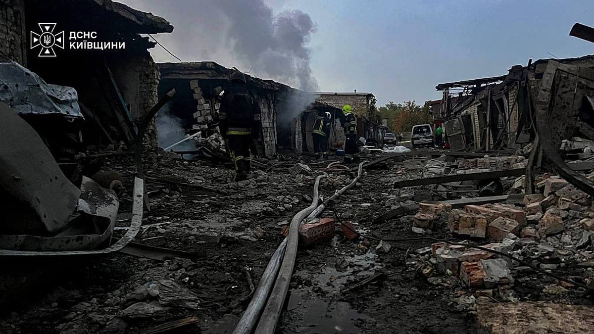 Bomberos trabajan entre los escombros de edificaciones destruidas por un ataque ruso en la región de Kiev